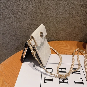 Detailed view of white quilted phone case bag with gold chain and rose buckle