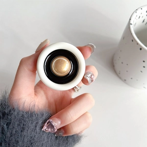 Detail of round white phone socket grip with elegant gold dome center and black trim