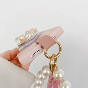 Detail of pink silicone phone case with pearl chain strap and gold ring attachment
