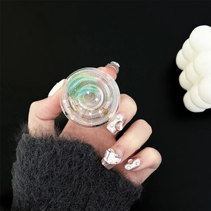 Close-up of clear resin phone grip featuring green planet design and glitter stars
