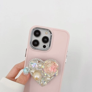 Detail of pink iPhone case featuring a rhinestone heart stand with pearl and rose accents
