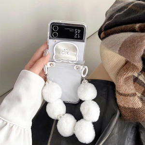 Detail of transparent foldable phone case with white plush wrist strap and bear mirror