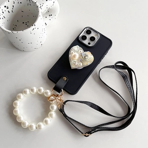 Detail of black iPhone case with pearl heart stand, pearl wrist strap and leather strap