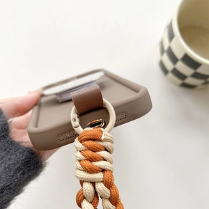 Detail of the brown matte phone case with braided crossbody strap and metal ring connector