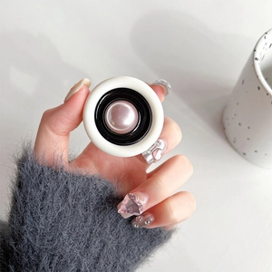 Close-up of a pearlescent pink and black telescopic phone grip held by hand