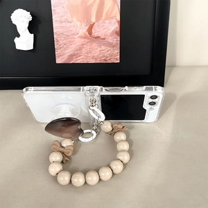 Detail of clear Samsung Z Flip 6 case with brown heart pop socket and beaded wrist strap
