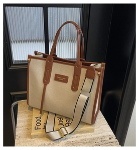 Détails des coutures en toile et cuir marron d'un grand sac cabas avec bandoulière
