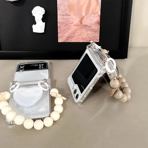 Detailed view of clear phone case with heart bracket and cream beaded handle strap