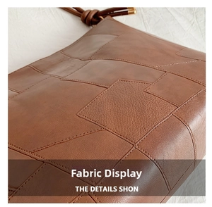 Detailed view of the brown leather patchwork design with precise stitching on a tote bag