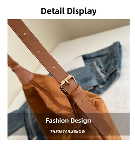 Detail view of brown suede shoulder bag with adjustable metal buckle and zipper closure