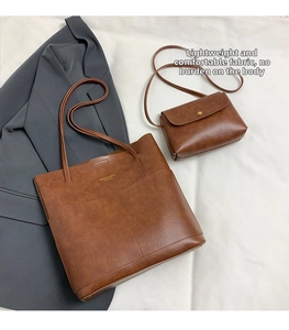 Detail of vintage brown leather tote and flap bag set with textured finish on white cloth