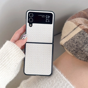 Detail of white woven texture on folding phone case with black frame held by hand