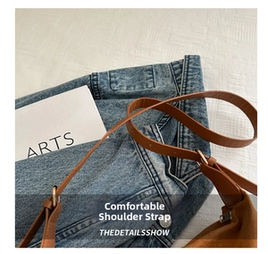 Detail of adjustable metal buckle on brown suede shoulder bag with leather strap
