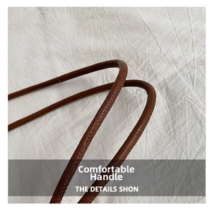 Close-up of comfortable brown leather handles with precise stitching on tote bag