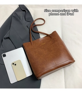 Brown leather tote bag size comparison with tablet showing large capacity and texture