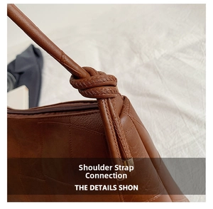 Close-up of the stylish leather knot detail on the shoulder strap of the brown tote bag