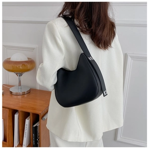 Detail of minimalist black crescent underarm bag with silver buckles on white blazer