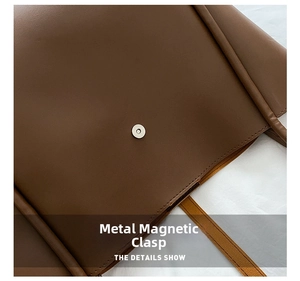 Detail of high-quality hardware magnetic buckle on a brown leather tote bag with fine stitching