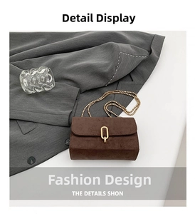 Close-up of brown frosted texture small square bag with golden chain and oval metal clasp