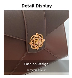 Close-up of brown leather envelope bag with vintage gold floral metal clasp detail