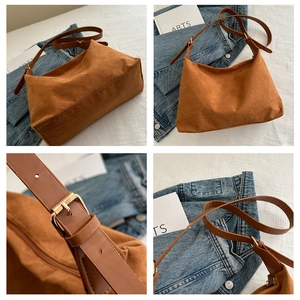Detailed close-up of brown suede underarm bag featuring adjustable golden metal buckle