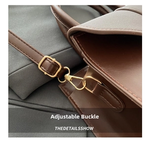 Detail of golden metal buckle and stitching on dark brown leather shoulder bag