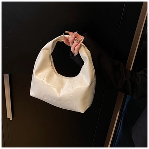 Close-up of beige cloud bag with geometric pleated texture and half-moon hobo structure