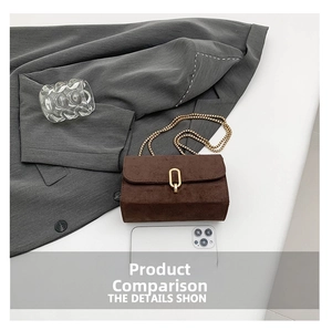 Detailed view of brown suede crossbody bag with gold lock and chain beside a smartphone