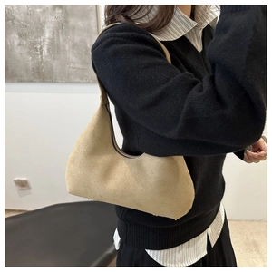 Detail of khaki suede hobo bag showing brushed texture and silver protective feet studs