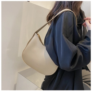 Minimalist cream white crescent shoulder bag shown on model in a modern side profile view
