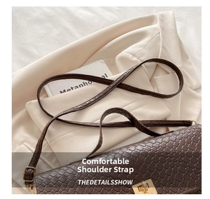 Detail of coffee brown woven crossbody bag with metallic buckle on a blazer background