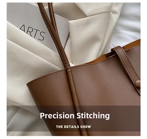 Detail of brown leather tote bag showing high-quality stitching and snap button closure