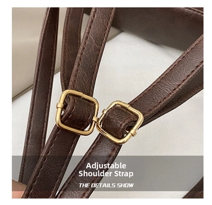 Detail of adjustable dark brown faux leather strap with square gold metal buckles