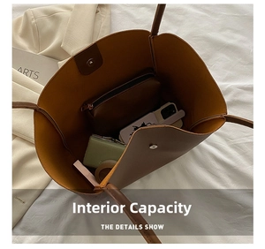 Detail of spacious interior of brown tote bag showing magnetic buckle and daily essentials