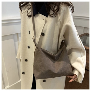 Deep brown suede shoulder bag styled on a model for a minimalist chic daily look