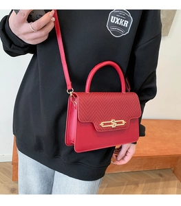Detail of red patchwork crossbody bag featuring herringbone fabric and gold clasp