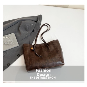 Detail of vintage brown tote bag texture and woven rope charm with gold metal ball