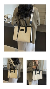 Détails du sac cabas en toile avec bordures en cuir noir, rivets et bandoulière réglable