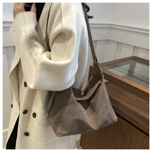 Detail of vintage brown faux suede hobo bag with adjustable gold buckle and soft pleats