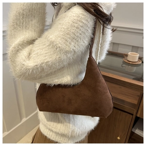 Detail of dark brown suede Hobo bag with minimalist vintage design and metal bottom studs
