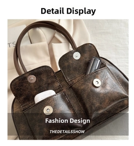 Dettaglio della borsa tote marrone vintage con tasche anteriori che mostrano lo spazio interno