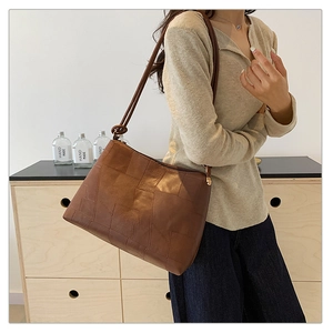 Detail of the brown geometric patchwork texture on this vintage-style tote bag