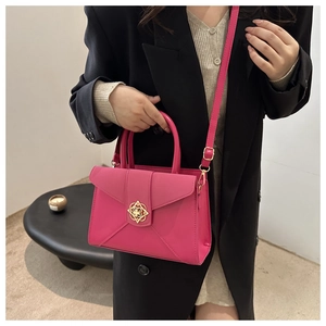 Detail of rose pink handbag with gold flower clasp and minimalist crossbody design
