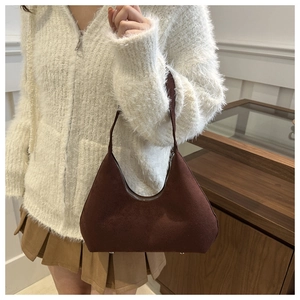 Brown frosted leather hobo bag styled with a white cardigan and pleated skirt