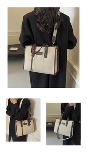 Vue détaillée du sac cabas en toile beige avec finitions en cuir brun et large bandoulière