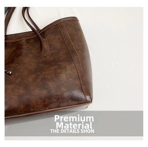 Detail shot of brown vintage textured PU leather tote bag with fine stitching