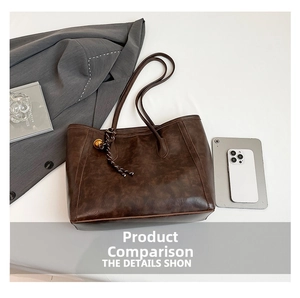 Deep brown vintage tote bag with woven ball charm shown alongside daily essentials