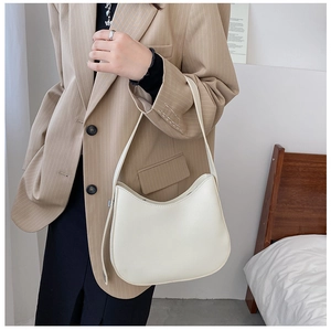 Chic cream leather hobo bag styled with a khaki striped blazer in a minimalist setting