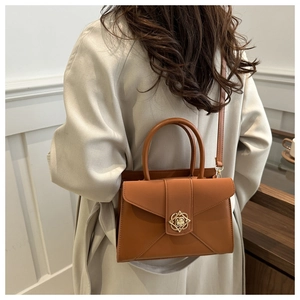 Detailed back view of a brown vintage shoulder bag with a gold floral metal lock buckle