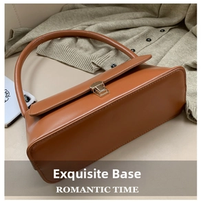 Détail de la base lisse et des coutures latérales d'un sac sous les bras en cuir brun